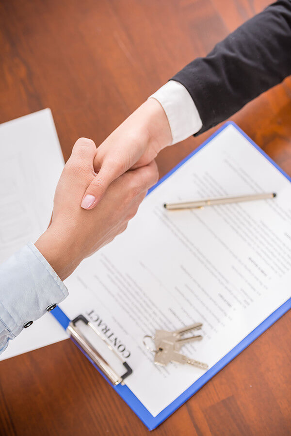 Realtor shaking hands over a contract