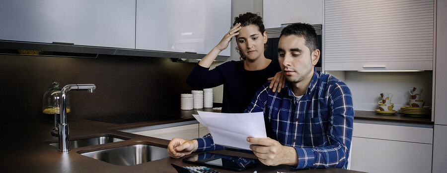 Unemployed young couple with many debts reviewing their bank accounts. Financial family problems concept.